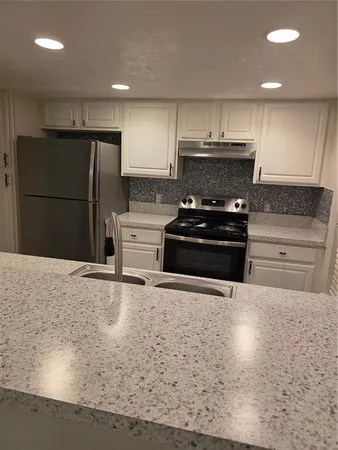 a kitchen with a sink stove and refrigerator