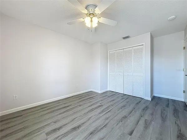 a view of an empty room with a floor to ceiling window with wooden floor