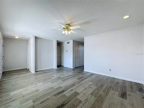 a view of an empty room with wooden floor