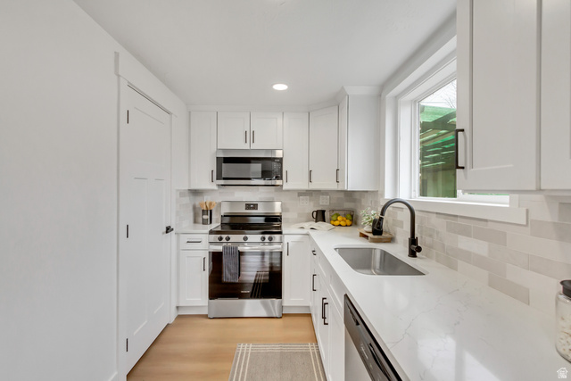337 West 2900th Street South Bountiful, UT 84010 - Photo 11 of 35 Kitchen featuring stainless steel appliances, white cabinets, light stone counters, decorative backsplash, and recessed lighting