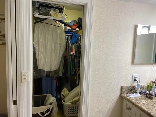 a bedroom with a bed chair and windows