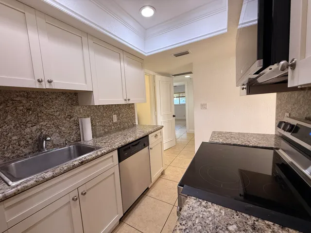 a kitchen with granite countertop a sink and stainless steel appliances