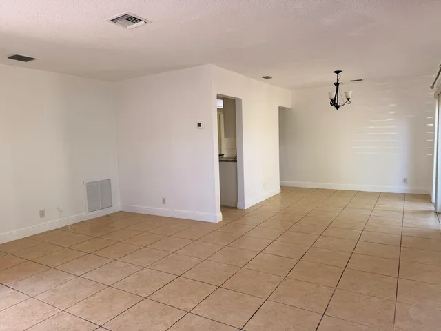 an empty room with kitchen view
