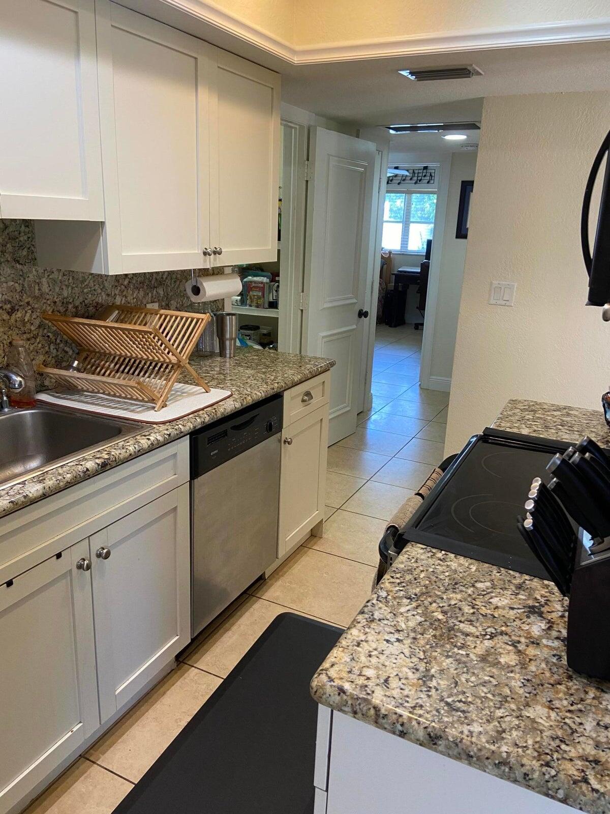 6797 Northeast 7th Avenue Boca Raton, FL 33487 - Photo 8 of 21 a kitchen with stainless steel appliances granite countertop a sink and cabinets