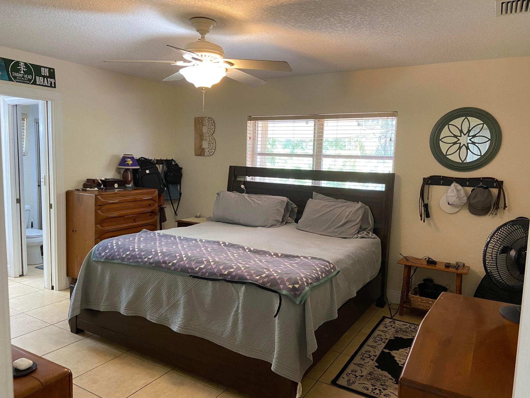 6797 Northeast 7th Avenue Boca Raton, FL 33487 - Photo 9 of 21 a bedroom with a bed and a chandelier