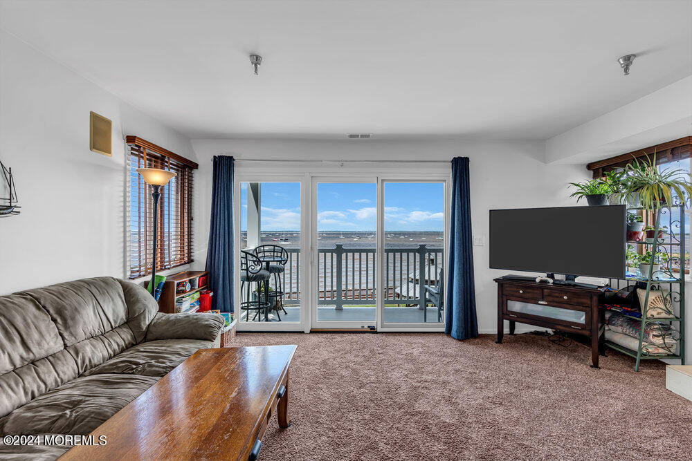 135 1st Street, Unit 2F Keyport, NJ 07735 - Photo 11 of 46 a living room with furniture a flat screen tv and a large window