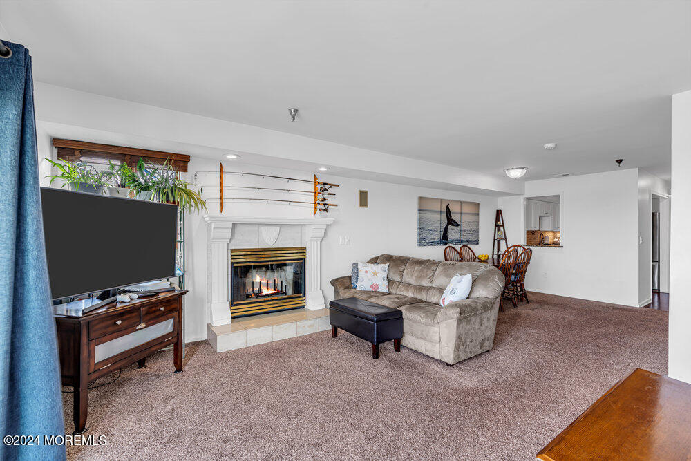 135 1st Street, Unit 2F Keyport, NJ 07735 - Photo 17 of 46 a living room with furniture a fireplace and a flat screen tv