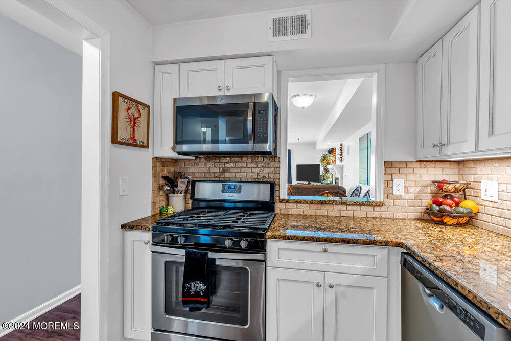 135 1st Street, Unit 2F Keyport, NJ 07735 - Photo 23 of 46 a kitchen with stainless steel appliances granite countertop a stove top oven a sink and cabinets