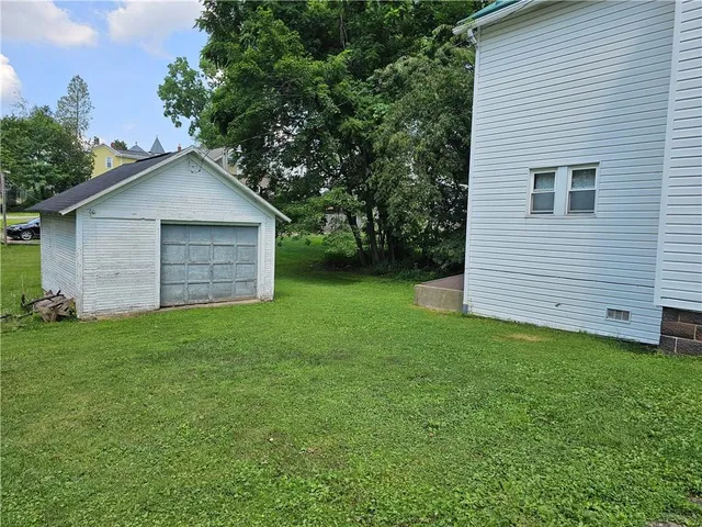 a view of a backyard with barn and large trees