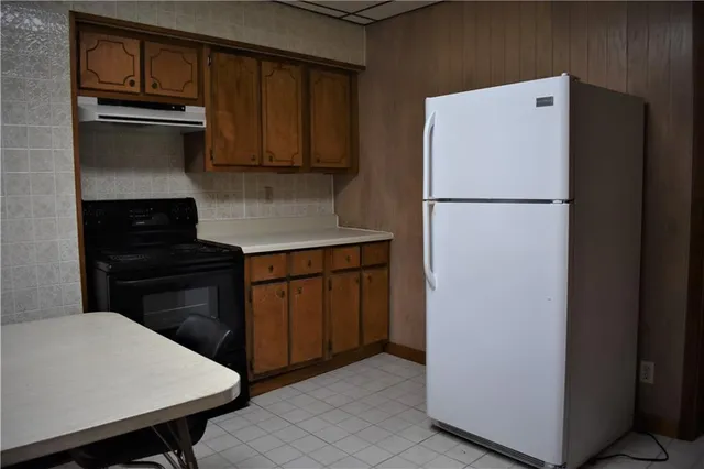 a kitchen with a refrigerator and a stove top oven