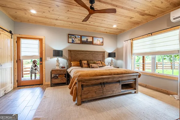 a bedroom with a large bed and wooden floor