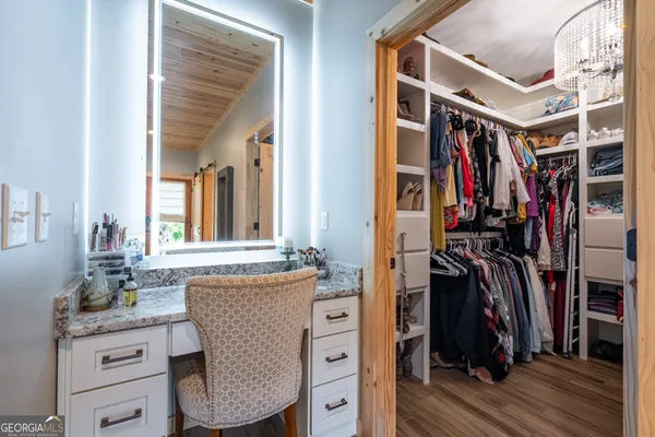a view of walk in closet with clothes and shoes