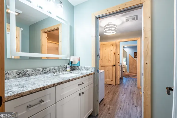 a en suite bathroom with a granite countertop sink mirror and a toilet