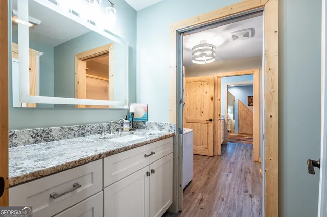 a en suite bathroom with a granite countertop sink mirror and a toilet