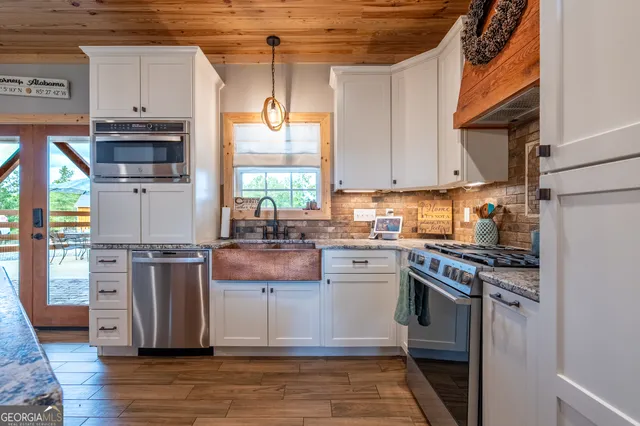 a kitchen with stainless steel appliances granite countertop a stove a sink and a refrigerator