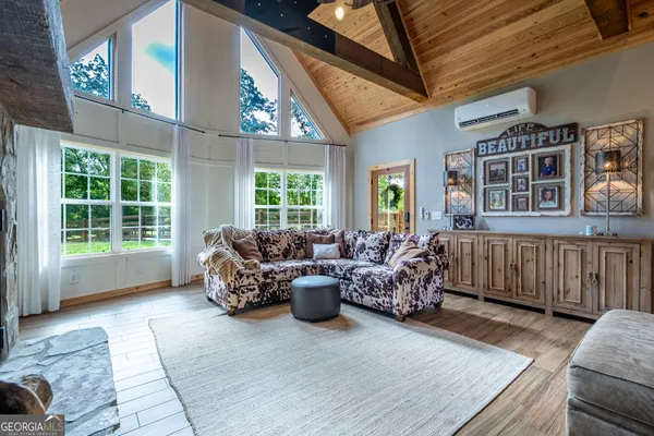 a living room with furniture stairs and a large window