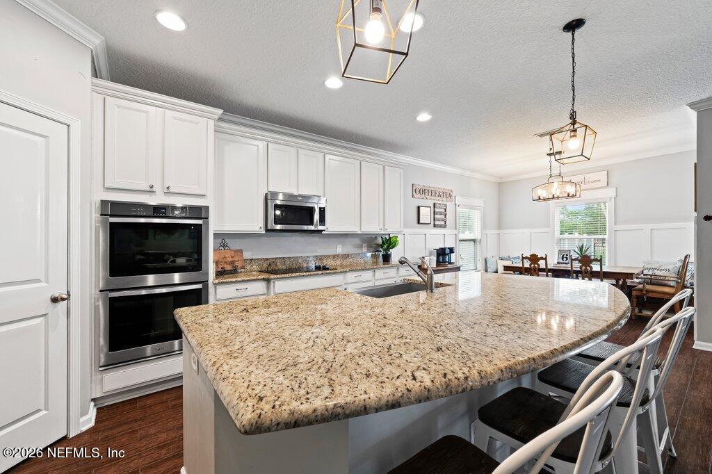 81015 Lockhaven Drive Yulee, FL 32097 - Photo 12 of 55 a kitchen with stainless steel appliances granite countertop a stove a refrigerator a sink a stove and a center island