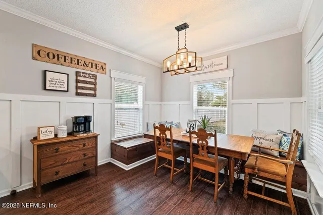 a view of a dining room with furniture wooden floor and a chandelier