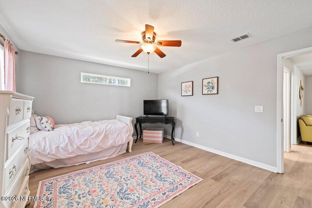 81015 Lockhaven Drive Yulee, FL 32097 - Photo 35 of 55 a bedroom with a bed and wooden floor