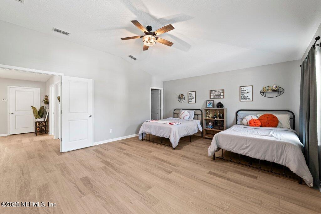 81015 Lockhaven Drive Yulee, FL 32097 - Photo 37 of 55 a bedroom with two beds and a chandelier