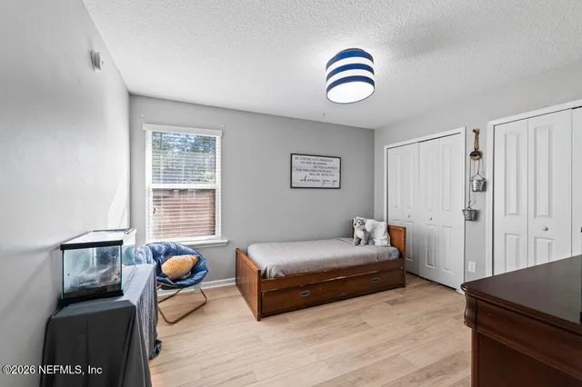 a view of a white house with a yard and large tree