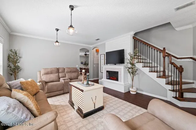 a living room with furniture a fireplace and a flat screen tv
