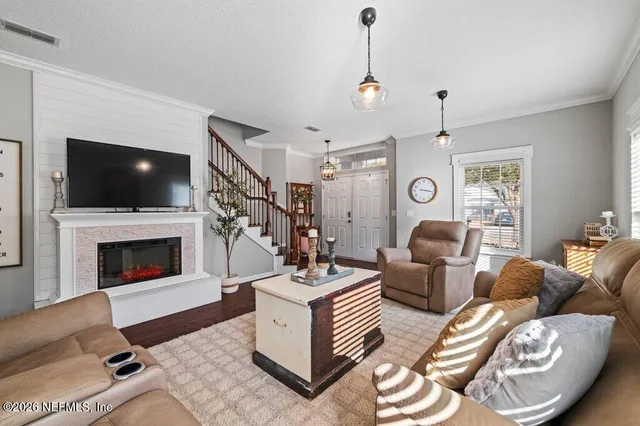 a living room with furniture a flat screen tv and a fireplace