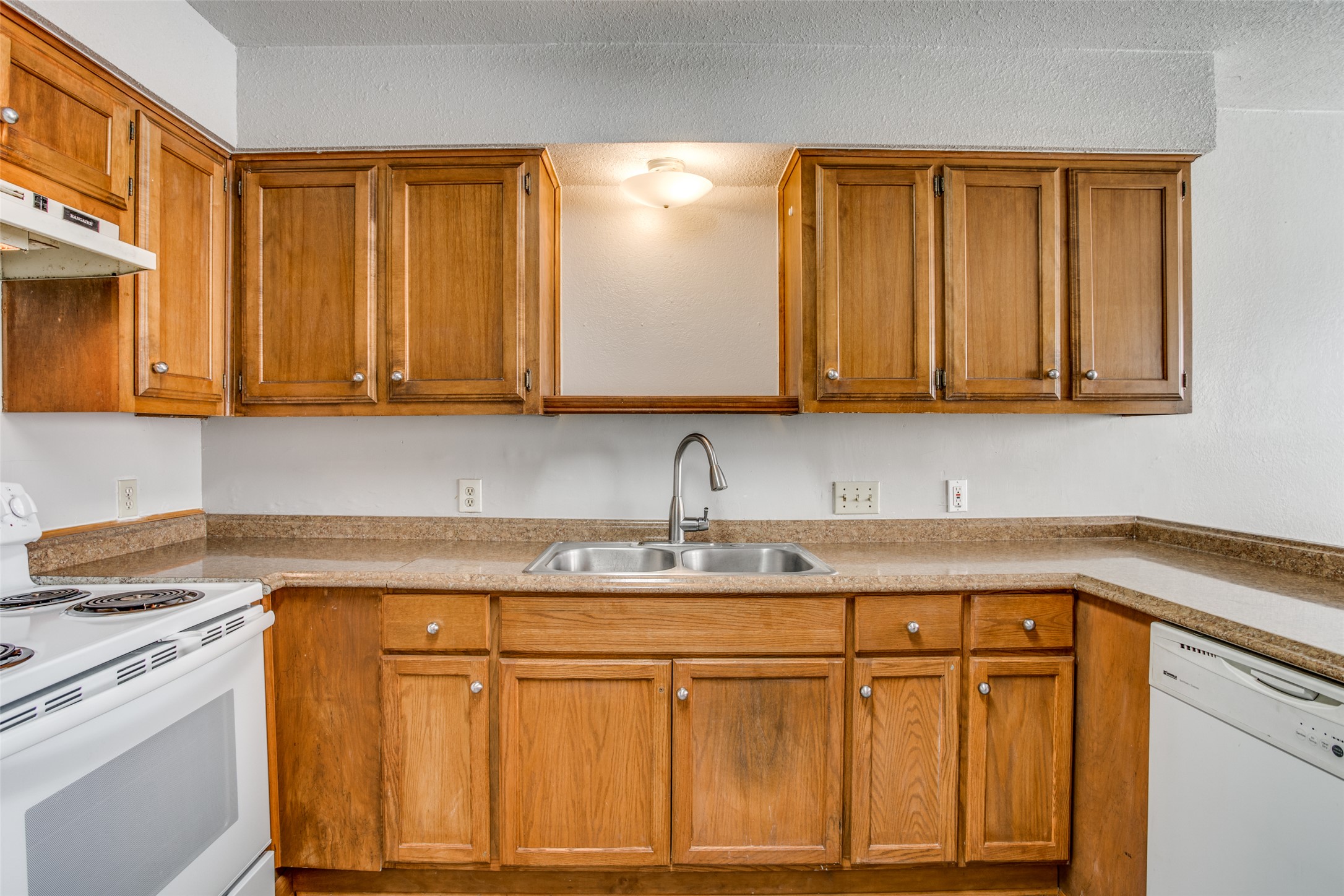 106 Verna Spur, Unit B Georgetown, TX 78628 - Photo 10 of 25 Functional kitchen with ample cabinet space, a dual basin sink, and classic white appliances.