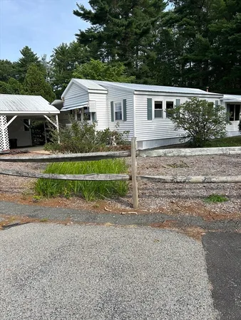 a view of a house with backyard and trees