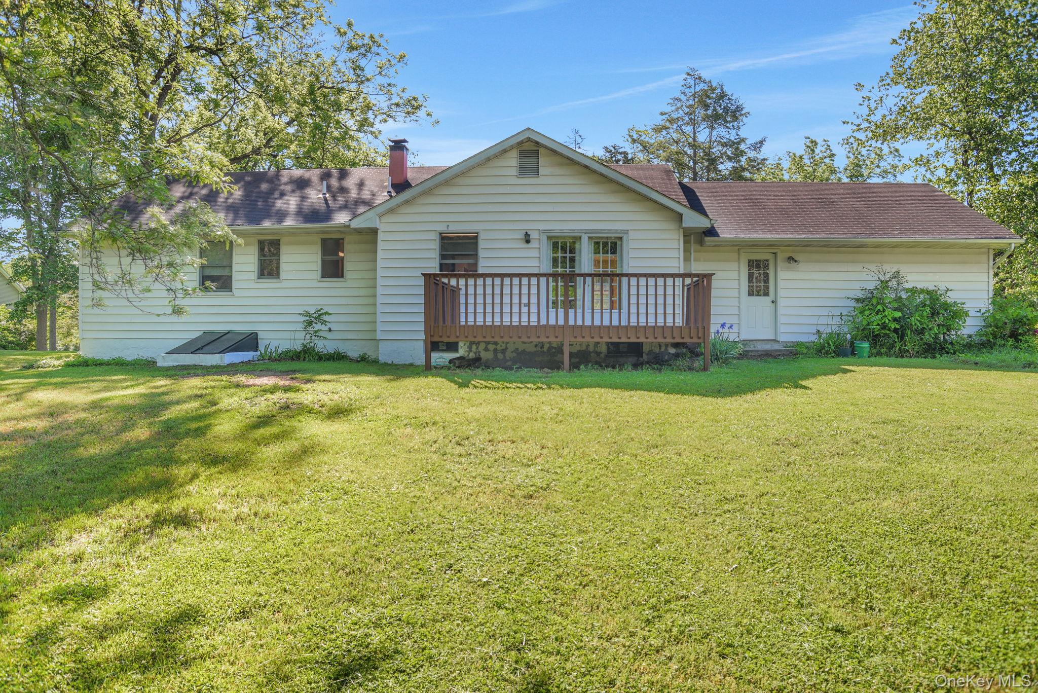 175 Overocker Road Poughkeepsie, NY 12603 - Photo 27 of 29 Rear exterior featuring white siding, a wooden deck, and a spacious grassy area