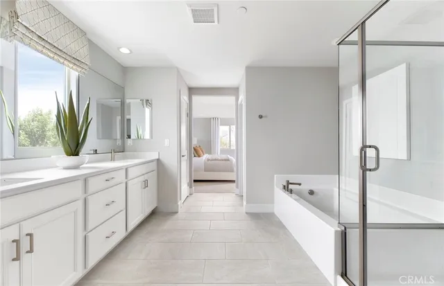 a spacious bathroom with a tub sink and mirror