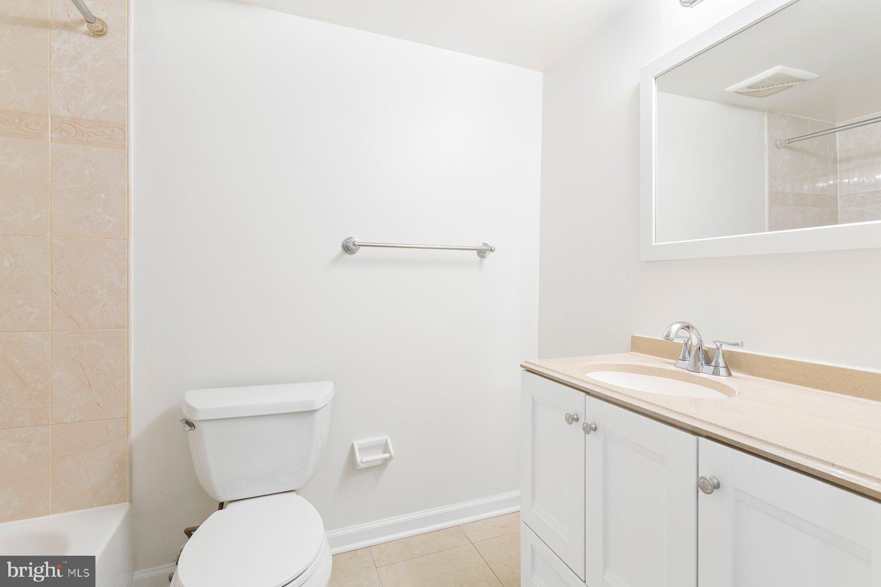 11234 Cherry Hill Road, Unit 304 Beltsville, MD 20705 - Photo 27 of 28 a bathroom with a toilet a sink and mirror