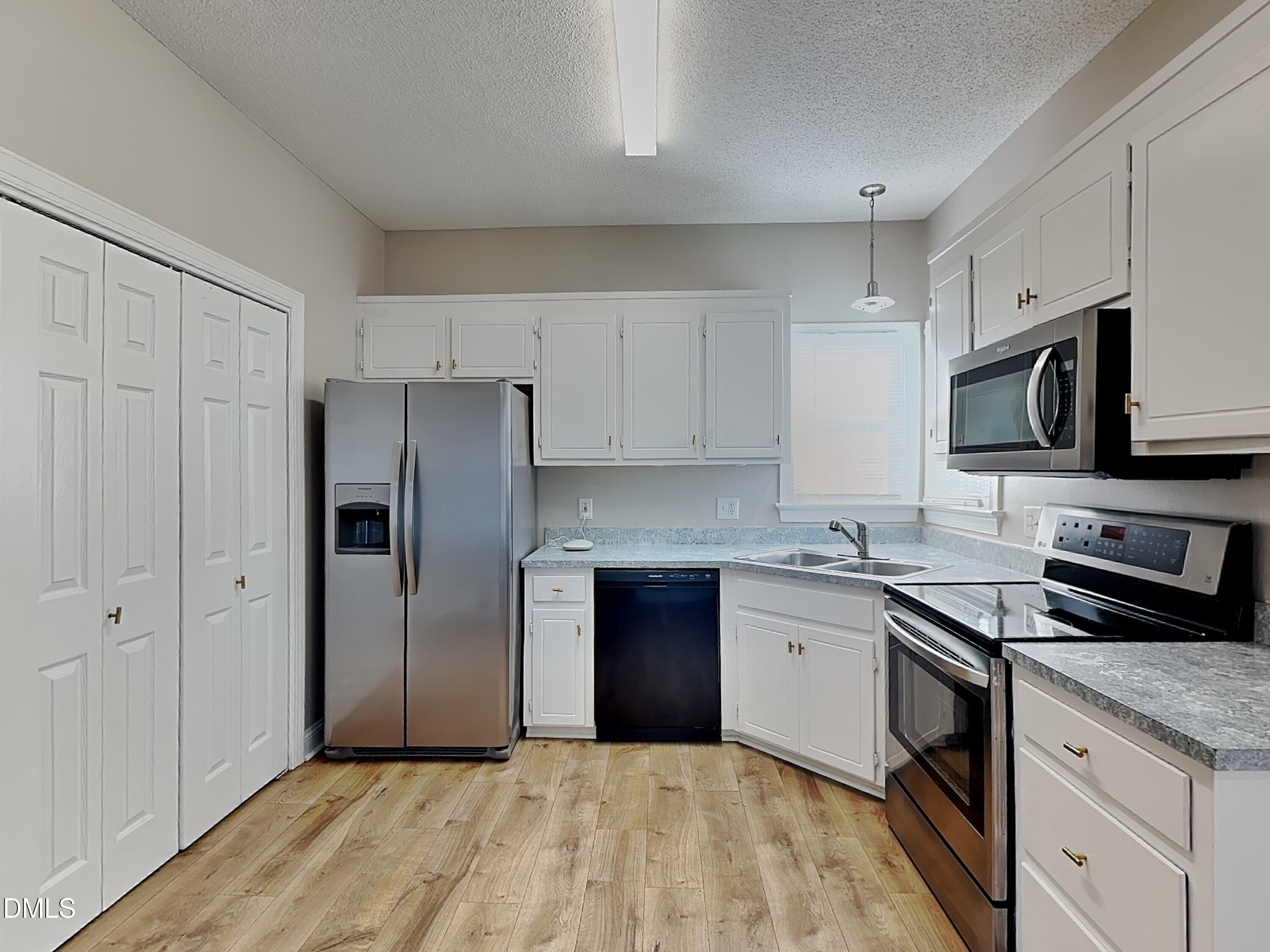 622 Commander Drive Wendell, NC 27591 - Photo 5 of 16 a kitchen with stainless steel appliances granite countertop a refrigerator sink and white cabinets
