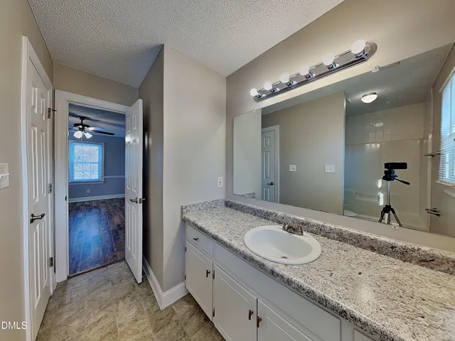 a bathroom with a granite countertop sink and a mirror