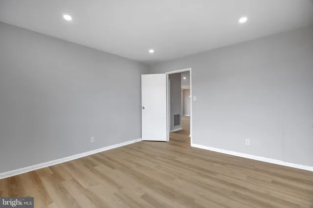 an empty room with wooden floor and window
