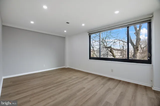 a view of empty room with wooden floor