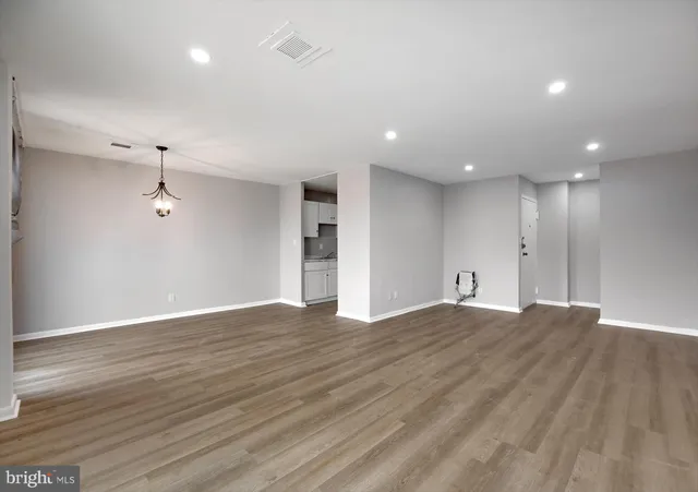 a view of an empty room with wooden floor