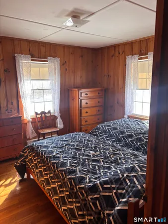 a bedroom with a bed and dresser with mirror