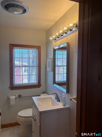 a bathroom with a toilet sink and mirror