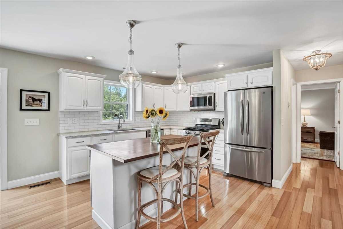 119 Ridge Road Clinton Corners, NY 12514 - Photo 16 of 31 a kitchen with stainless steel appliances granite countertop a refrigerator a sink dishwasher a stove and white cabinets with wooden floor
