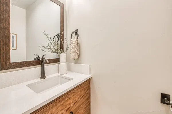 a spacious bathroom with double vanity a sink a large mirror a bathtub and next to a window