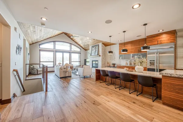 a kitchen with stainless steel appliances granite countertop a stove a kitchen island a dining table and chairs with wooden floor