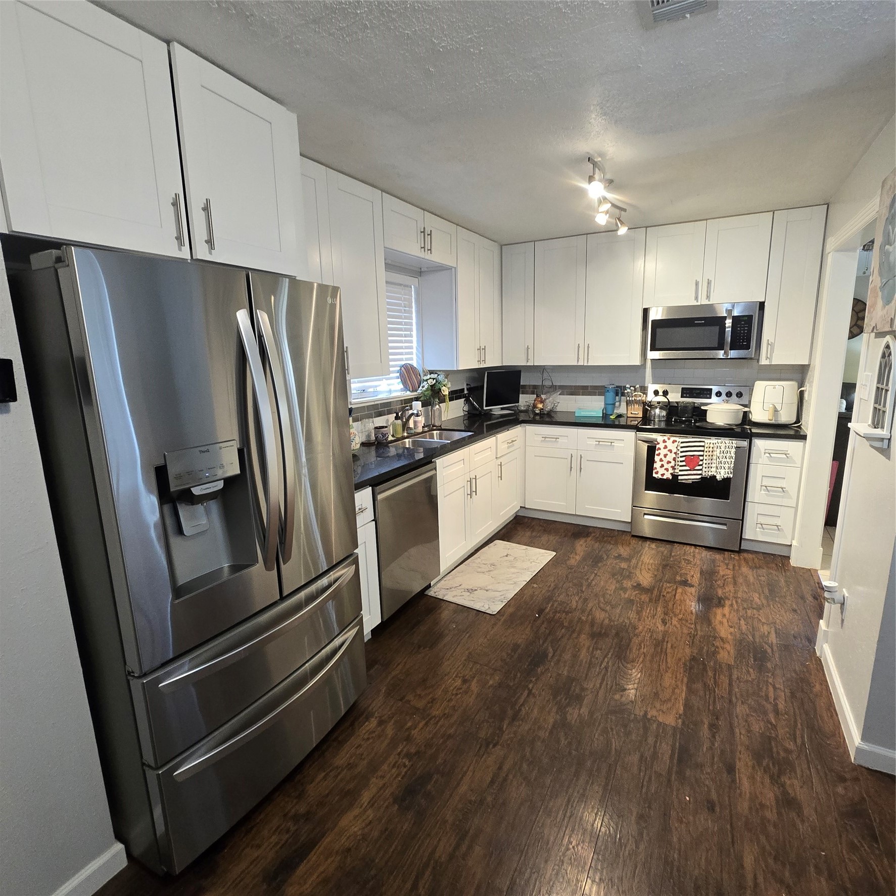 22527 Millgate Drive Spring, TX 77373 - Photo 11 of 30 a kitchen with granite countertop stainless steel appliances a refrigerator a stove top oven and sink