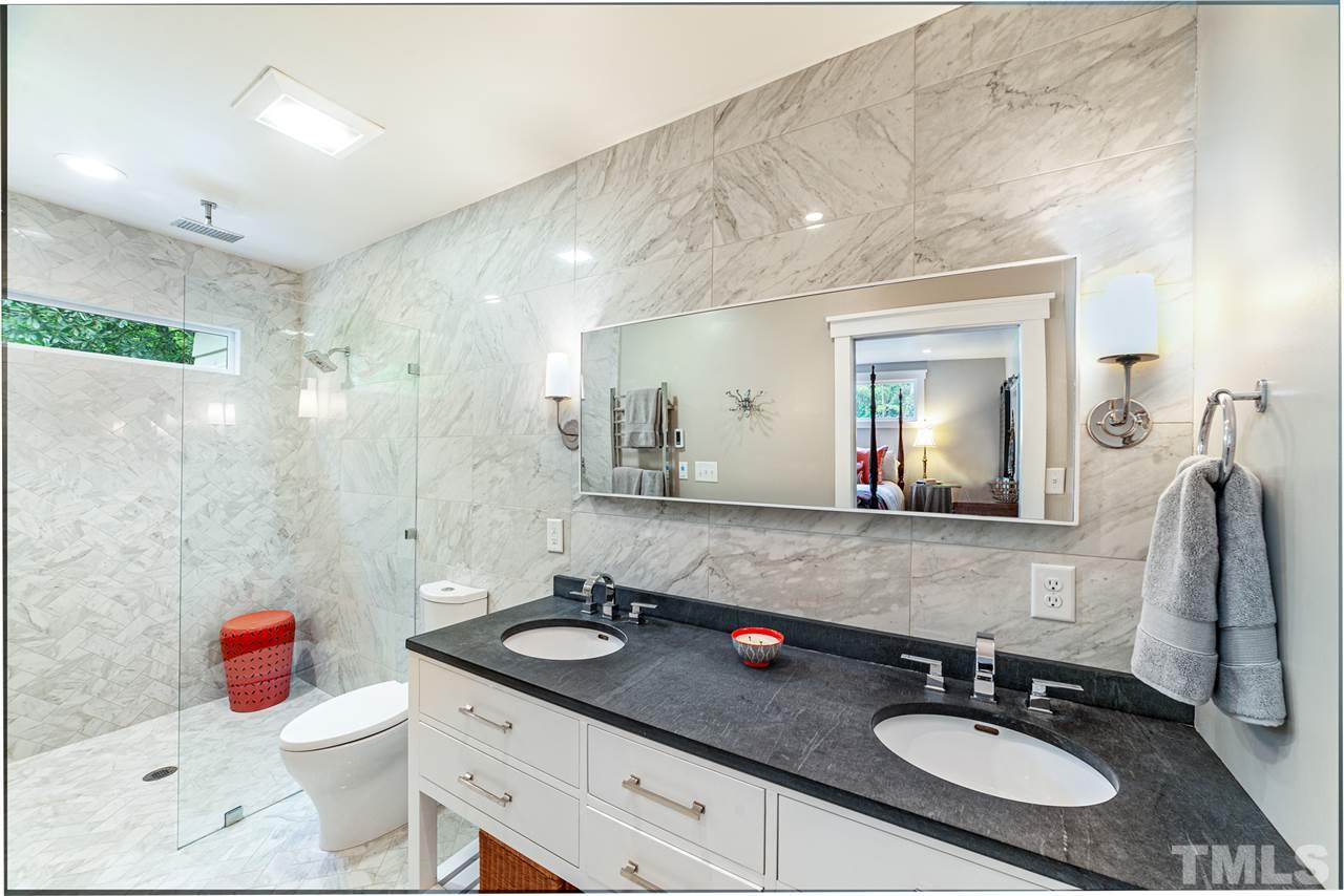 2251 Cranford Road Durham, NC 27705 - Photo 17 of 30 The spa like Master Ensuite bathroom features heated marble flooring, floor to ceiling marble tile, towel warmer, zero entry fixed frameless glass shower screen with ceiling-mount rainfall shower plus double vanity.