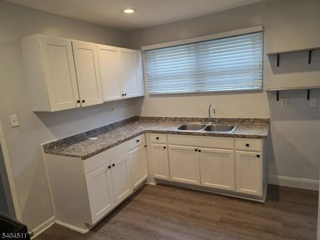 a kitchen with granite countertop white cabinets and a sink