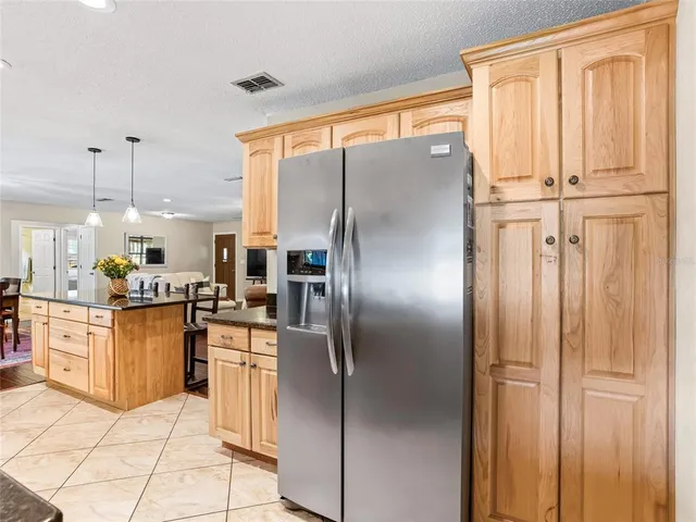 a kitchen with stainless steel appliances granite countertop a refrigerator a oven a sink and white cabinets