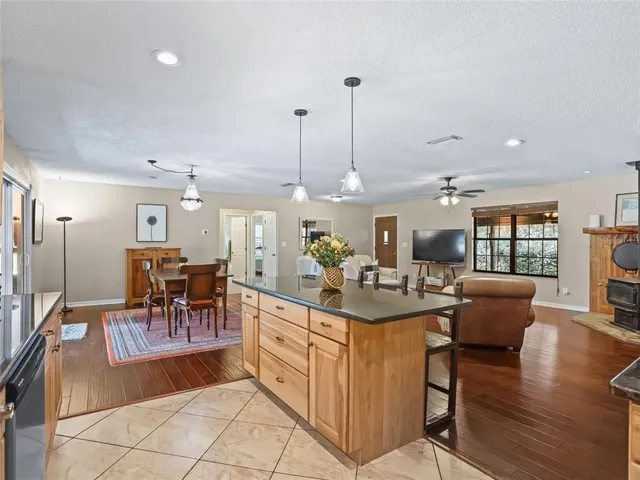 a view of a dining room and livingroom with furniture wooden floor a chandelier