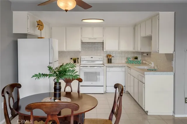 a kitchen with stainless steel appliances a table and chairs in it