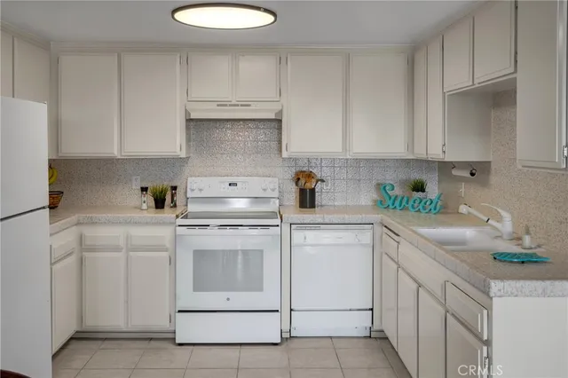 a kitchen with cabinets appliances a sink and a counter top