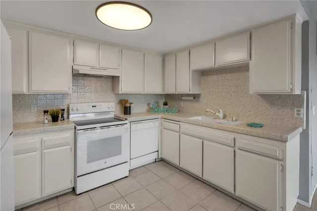 a kitchen with white cabinets stainless steel appliances and sink